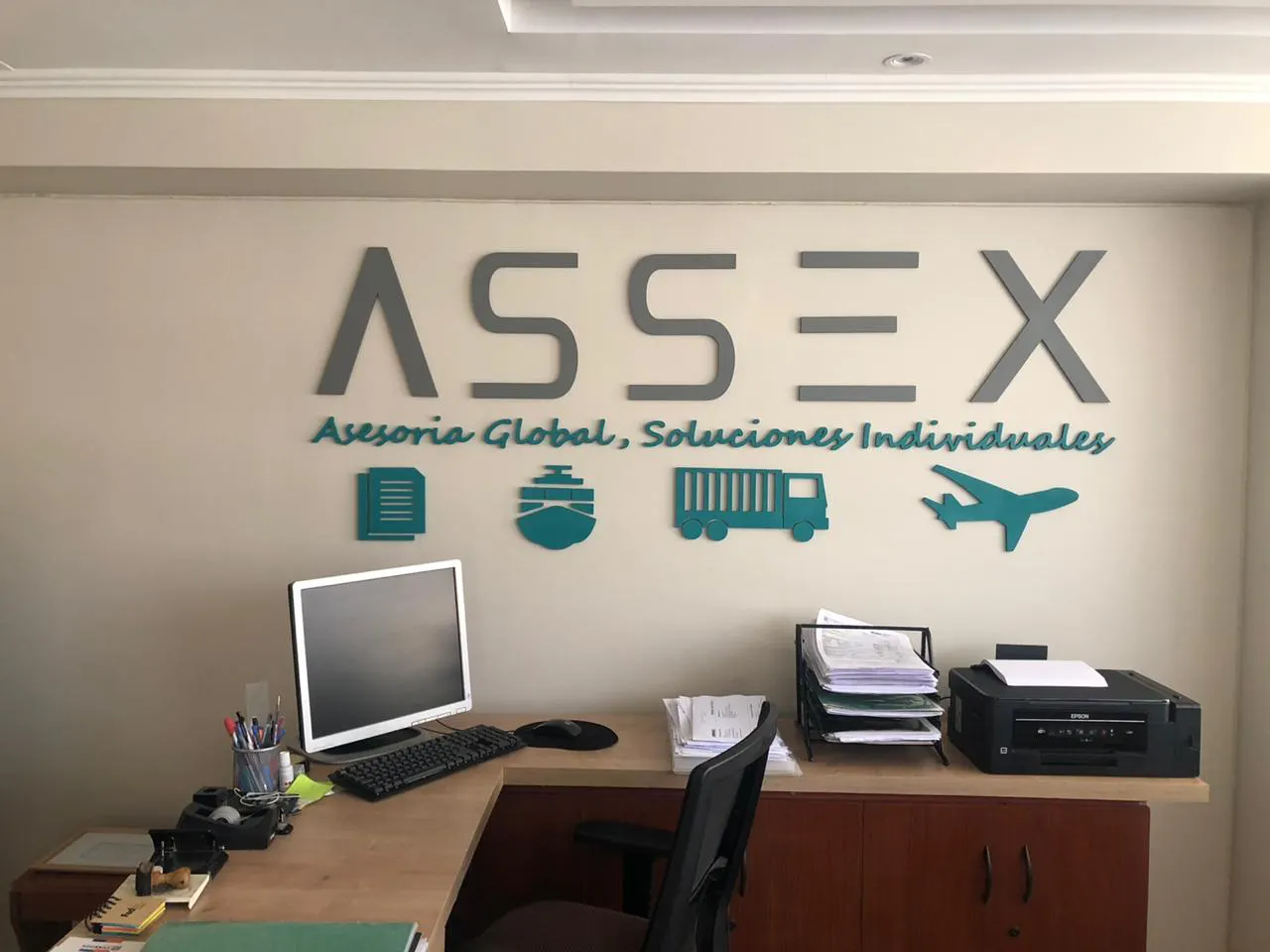 Recepción de la oficina de ASSEX con el logo en la pared