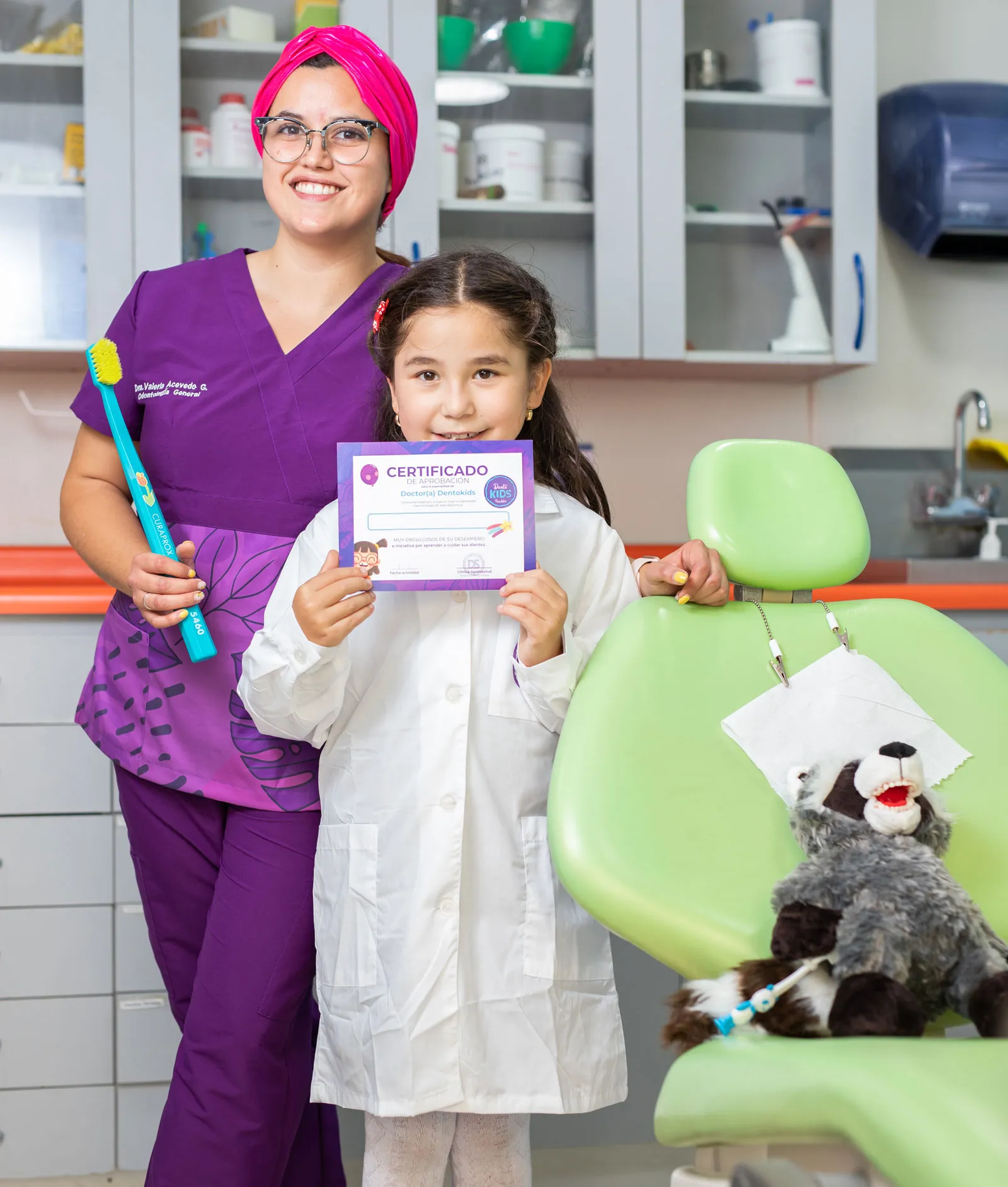 Niña con su diploma Dentokids junto a su odontopediatra